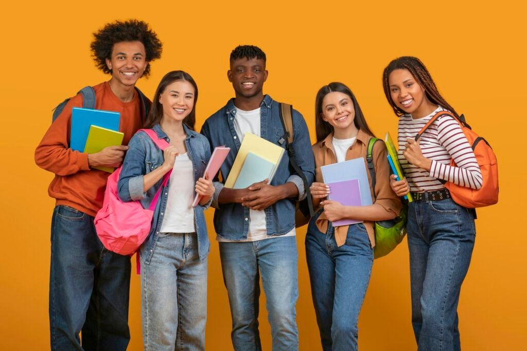 Student friends with books and backpacks smiling