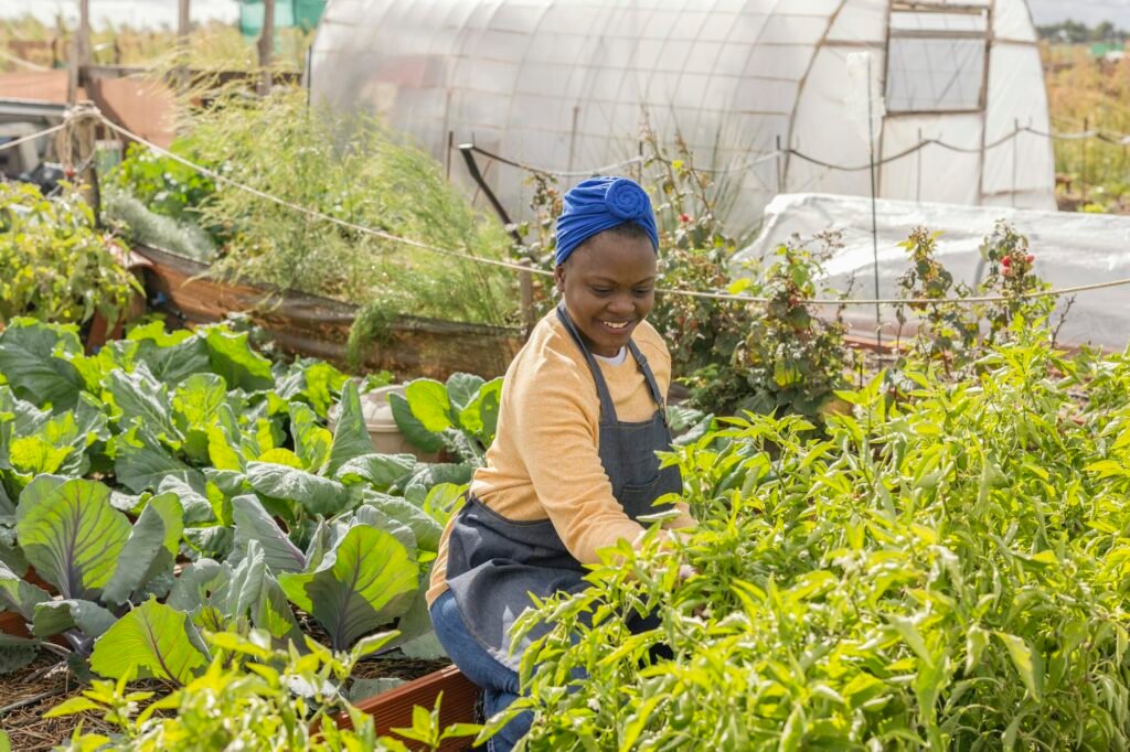 Young Woman Smiling in Lush Vegetable Garden